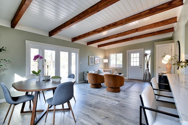 dining area with light wood-style floors, french doors, beamed ceiling, and baseboards