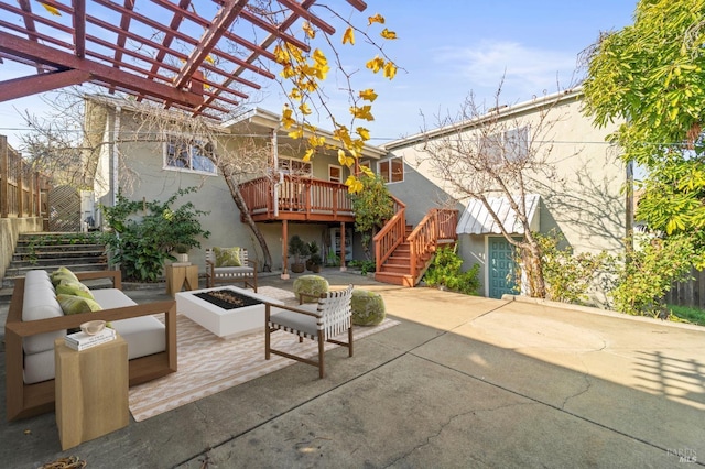 view of patio featuring a pergola, a deck, and an outdoor living space with a fire pit