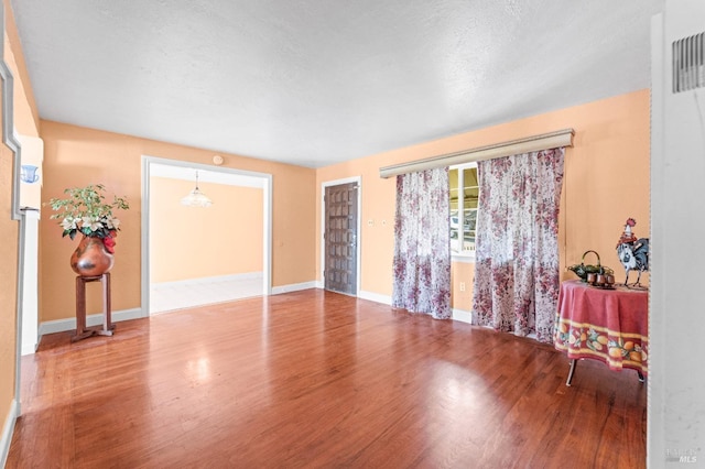 spare room with hardwood / wood-style flooring and a textured ceiling