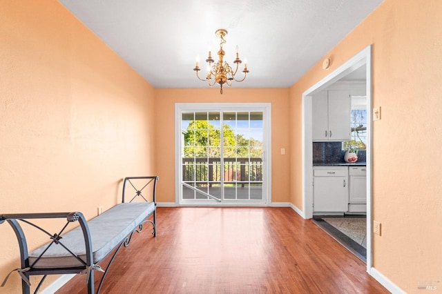 sitting room featuring wood finished floors, baseboards, and a chandelier