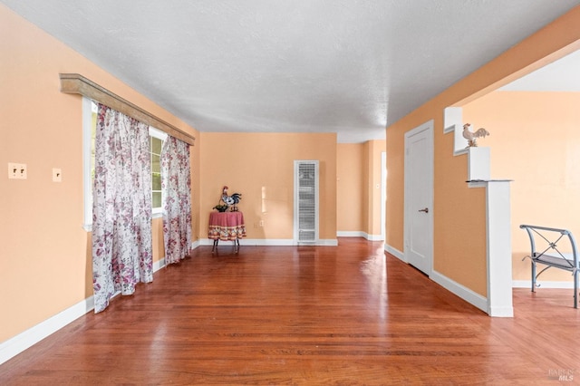 unfurnished room featuring hardwood / wood-style floors and a textured ceiling