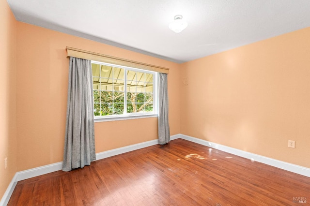 empty room with wood finished floors and baseboards