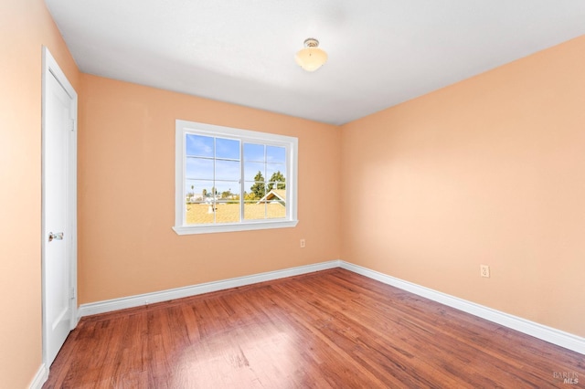 unfurnished room featuring wood finished floors and baseboards