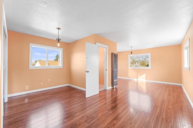 spare room featuring hardwood / wood-style floors and a textured ceiling