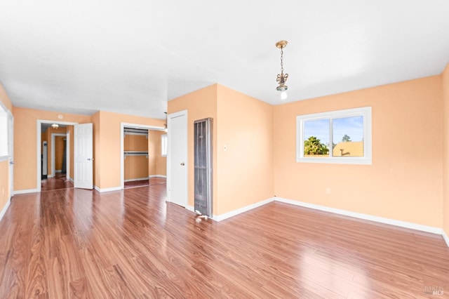 unfurnished room featuring baseboards and light wood-style flooring