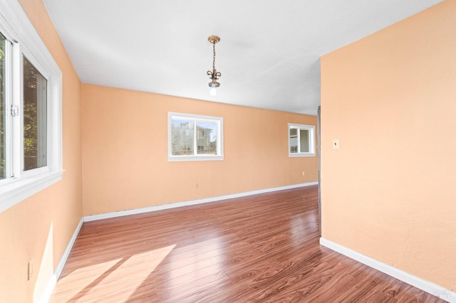 spare room featuring baseboards and wood finished floors