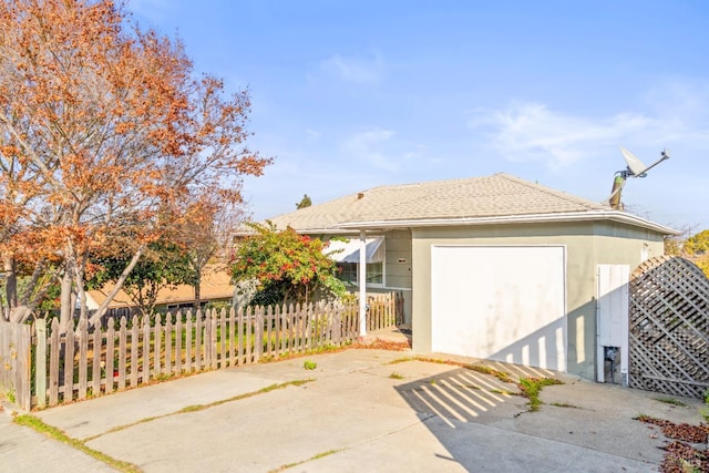 view of front of home with a fenced front yard, stucco siding, and a shingled roof