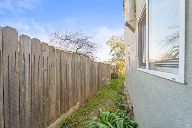 view of property exterior with stucco siding and fence