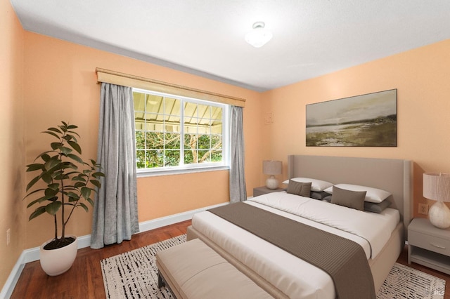 bedroom featuring baseboards and wood finished floors