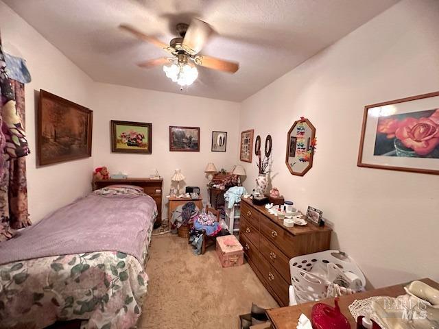 bedroom featuring light carpet and ceiling fan