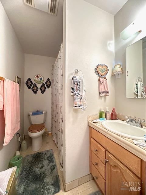 bathroom featuring tile patterned flooring, vanity, and toilet