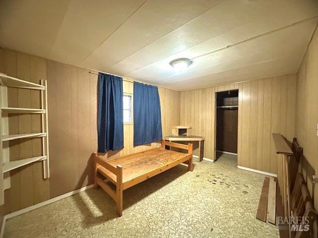 bedroom with wood walls and a closet