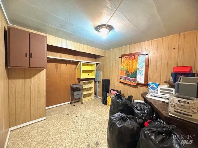 carpeted home office with wooden walls