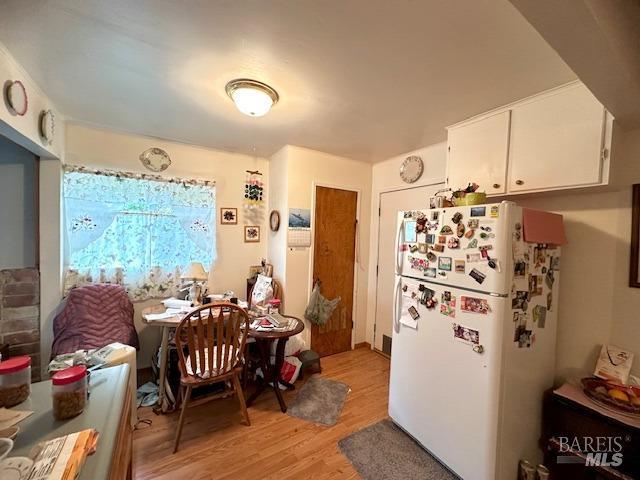 kitchen featuring white cabinets, light hardwood / wood-style floors, and white refrigerator