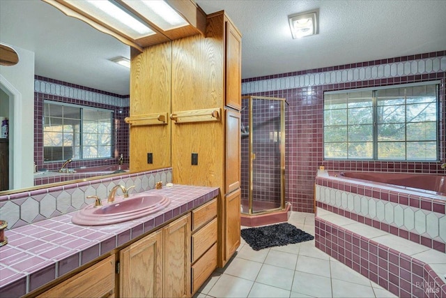 bathroom featuring separate shower and tub, tile patterned flooring, vanity, and a textured ceiling