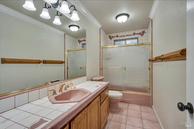 full bathroom featuring combined bath / shower with glass door, tile patterned floors, ornamental molding, vanity, and toilet