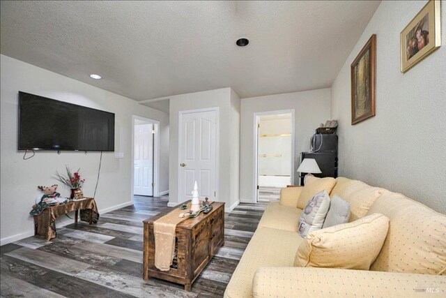 living room with dark wood-type flooring and a textured ceiling