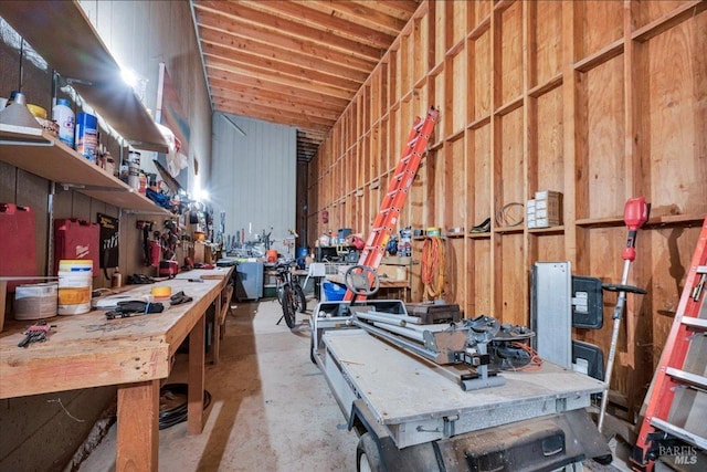 misc room featuring a workshop area and wooden walls