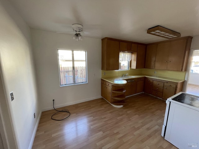 kitchen featuring ceiling fan, sink, white electric range oven, and light wood-type flooring