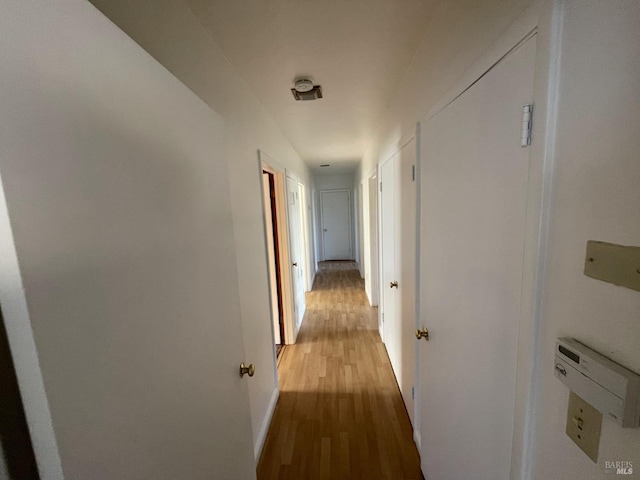 hall featuring baseboards and light wood finished floors