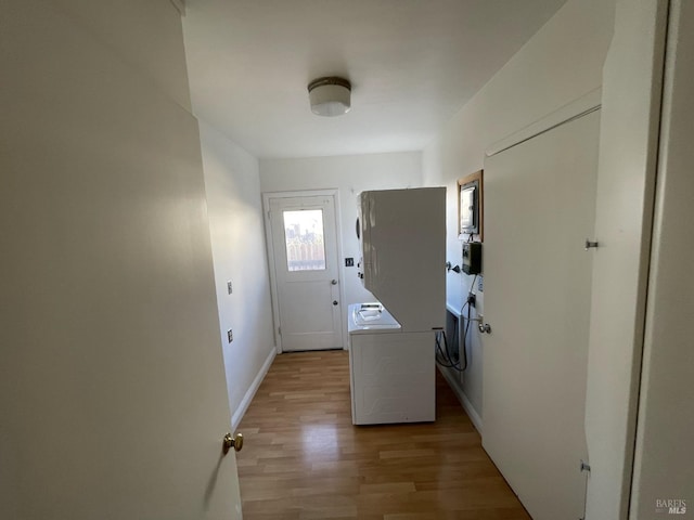 entryway with baseboards, washer / dryer, and light wood-type flooring