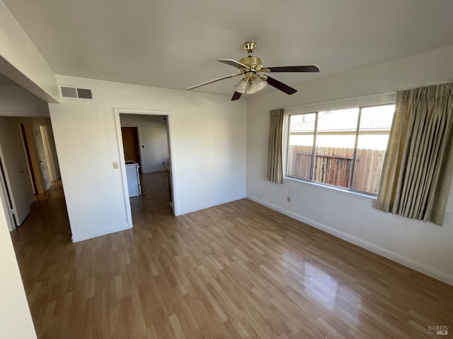 unfurnished room featuring wood finished floors, visible vents, baseboards, and a ceiling fan