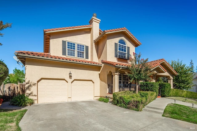 mediterranean / spanish-style home featuring covered porch and a garage