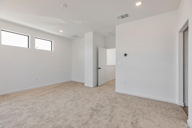 unfurnished room featuring baseboards, light colored carpet, recessed lighting, and visible vents