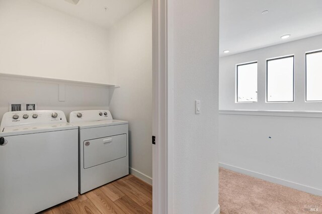 clothes washing area featuring baseboards, laundry area, and washing machine and dryer