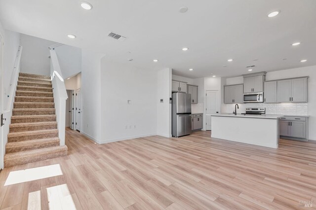 kitchen featuring visible vents, a sink, gray cabinetry, and stainless steel appliances