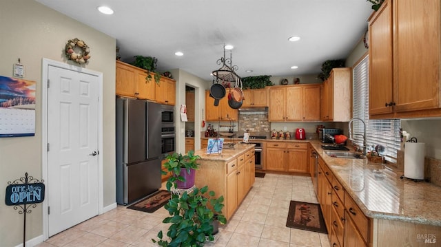 kitchen with light tile patterned flooring, light stone counters, sink, and appliances with stainless steel finishes