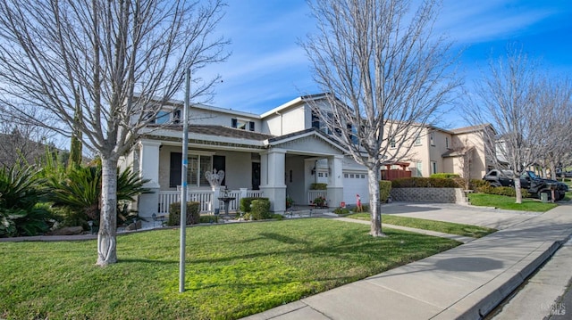 view of front of home with a front yard, a porch, and a garage