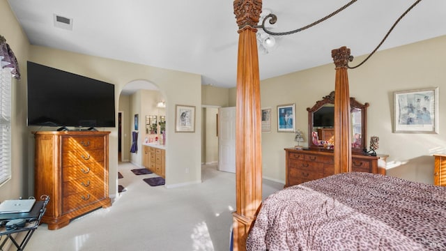 carpeted bedroom featuring ensuite bath