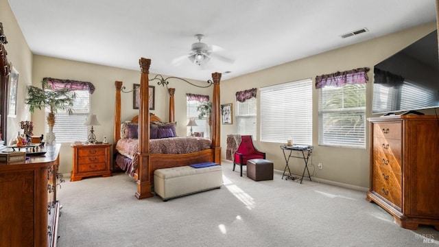 bedroom with multiple windows, ceiling fan, and light colored carpet