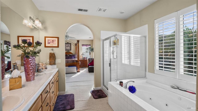 bathroom featuring vanity and independent shower and bath