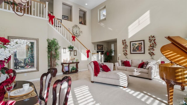 carpeted living room with plenty of natural light and a high ceiling