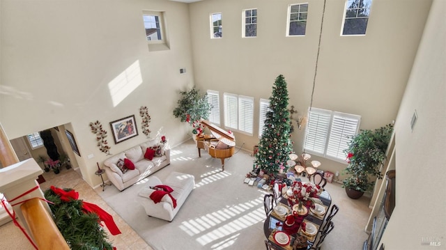 living room with carpet flooring and a towering ceiling