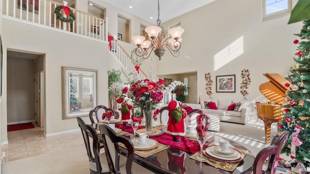 dining area featuring a notable chandelier, light tile patterned flooring, and a towering ceiling