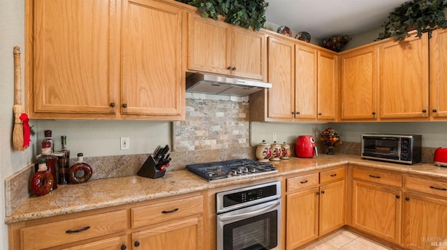 kitchen featuring light stone countertops, light tile patterned flooring, and stainless steel appliances