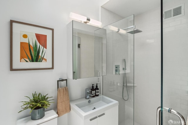 bathroom with sink, an enclosed shower, and toilet