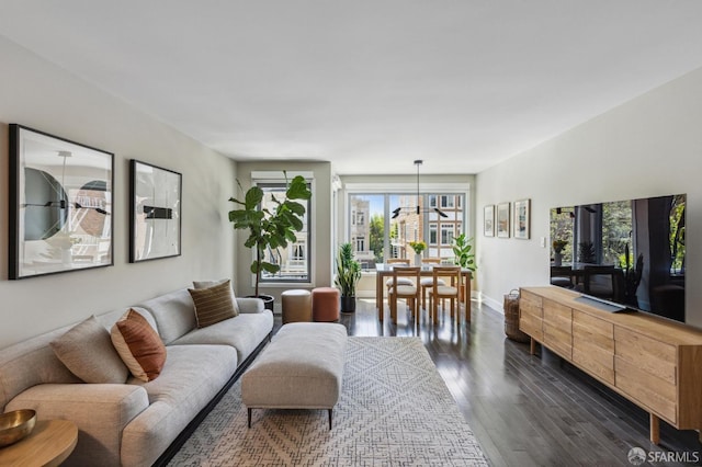 living room with a chandelier and dark hardwood / wood-style floors