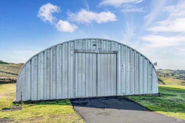 view of outbuilding featuring a lawn