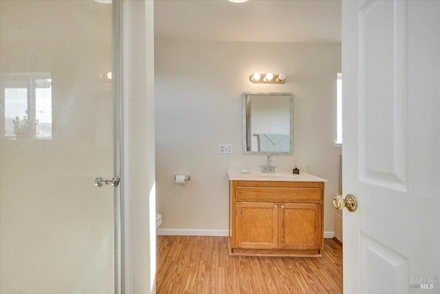 bathroom featuring vanity, hardwood / wood-style flooring, and toilet