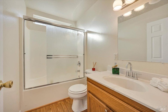 full bathroom featuring wood-type flooring, vanity, toilet, and enclosed tub / shower combo