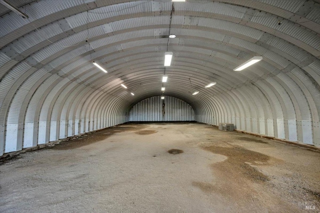 misc room featuring concrete floors, vaulted ceiling, and brick ceiling