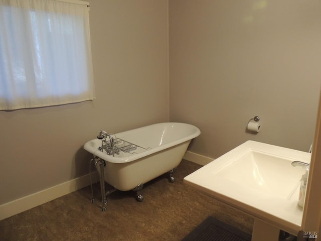 bathroom featuring sink and a tub to relax in