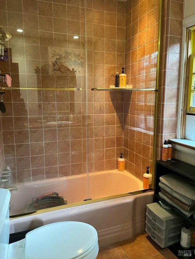 bathroom featuring washtub / shower combination, tile patterned floors, and toilet