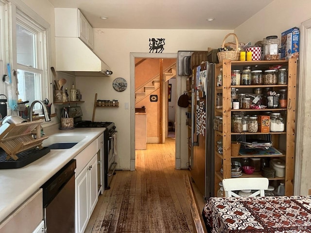 kitchen with sink, white cabinets, stainless steel appliances, and light hardwood / wood-style floors