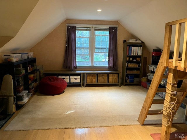 additional living space with light hardwood / wood-style floors and vaulted ceiling