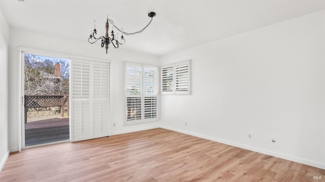 unfurnished dining area featuring light wood-type flooring and an inviting chandelier